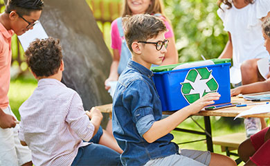 Nachhaltig & Sozial Gruppe von Kindern sitzen auf Bänken und engagieren sich für Nachhaltigkeit